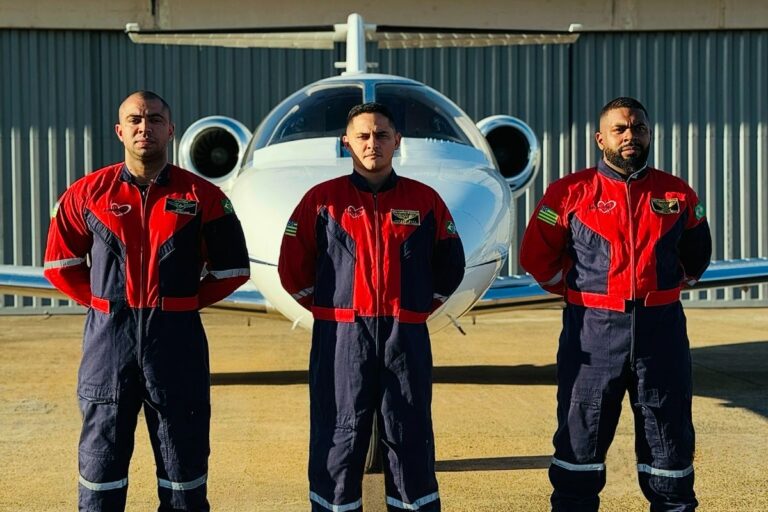 Homens posando para foto de braços cruzados em frente ao avião