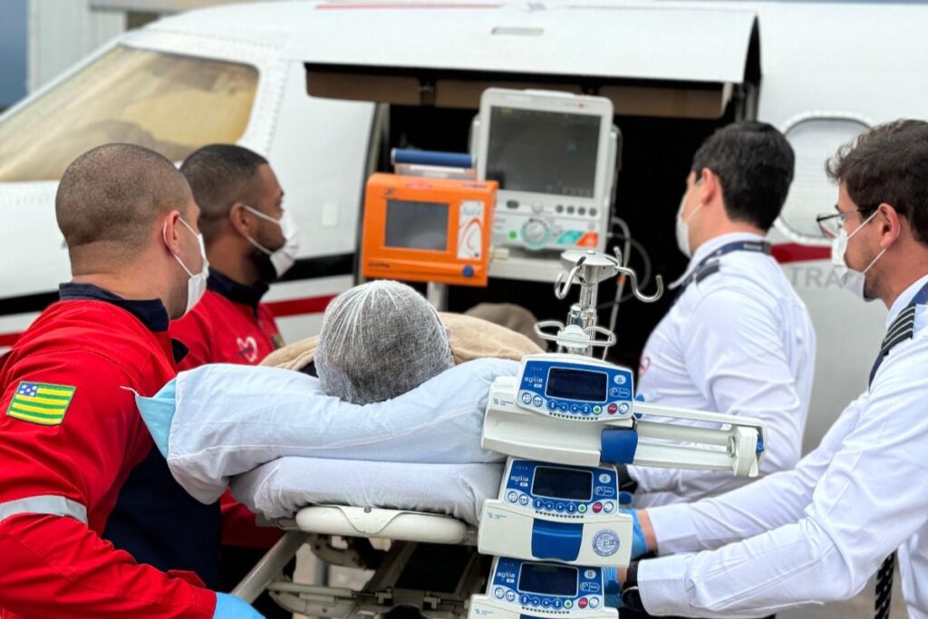Paciente sendo transportado para avião