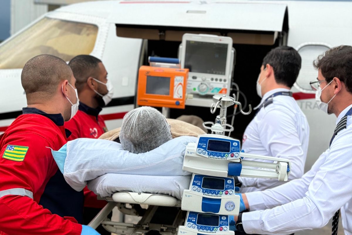 Paciente sendo transportado para avião
