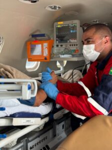 Médico segurando a mão de paciente durante atendimento em uma UTI aérea