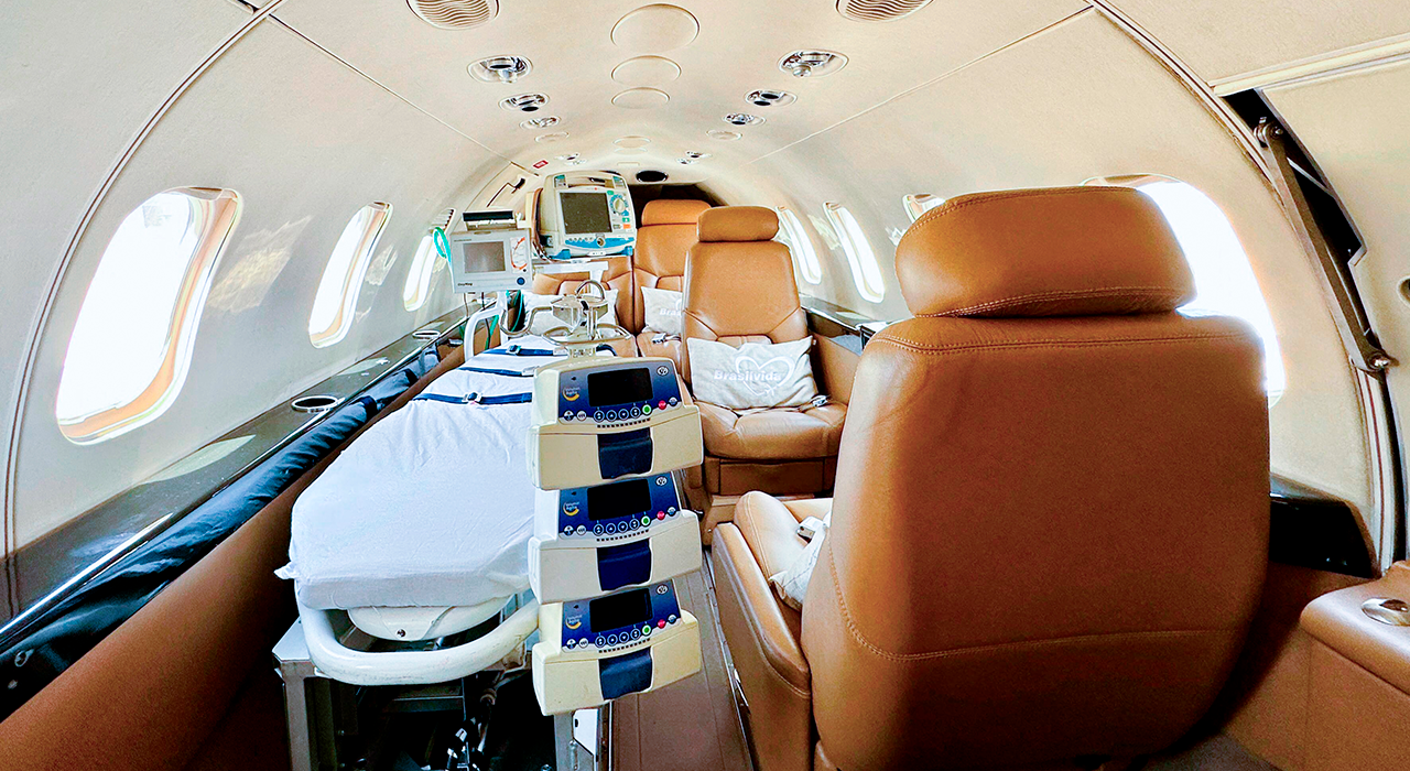 Interior de uma UTI aérea equipada com maca, monitores e equipamentos médicos para transporte aeromédico de pacientes que necessitam de cuidados intensivos durante o voo.