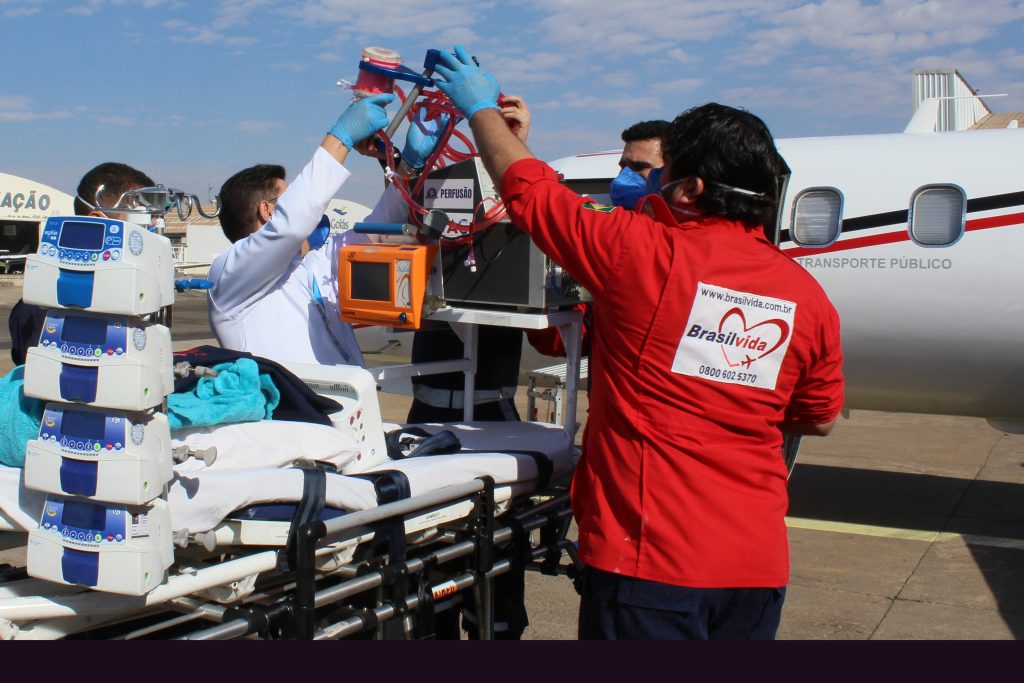 Equipe especializada preparando aeronave e equipamentos para missão de transporte aeromédico.